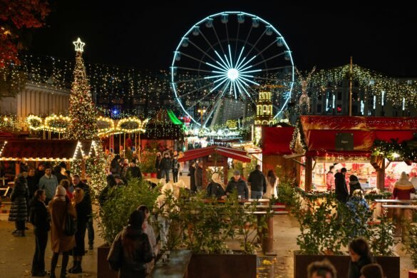 A vibrant Christmas market at night, adorned with festive lights and decorations. People are enjoying the holiday atmosphere, browsing through various stalls. In the background, a large illuminated Ferris wheel and a beautifully decorated Christmas tree add to the enchanting scene. The market is filled with cheerful visitors, warmly dressed for the winter evening.